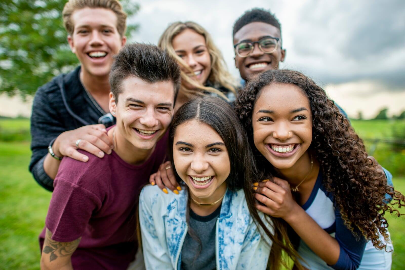 Group of six students middle school/high school aged smiling. 